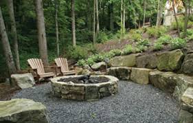 Natural stone hardscape area with a fire pit and moss covered stone seating.